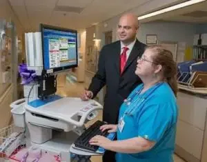 Dr. Karkare con traje, mirando radiografías